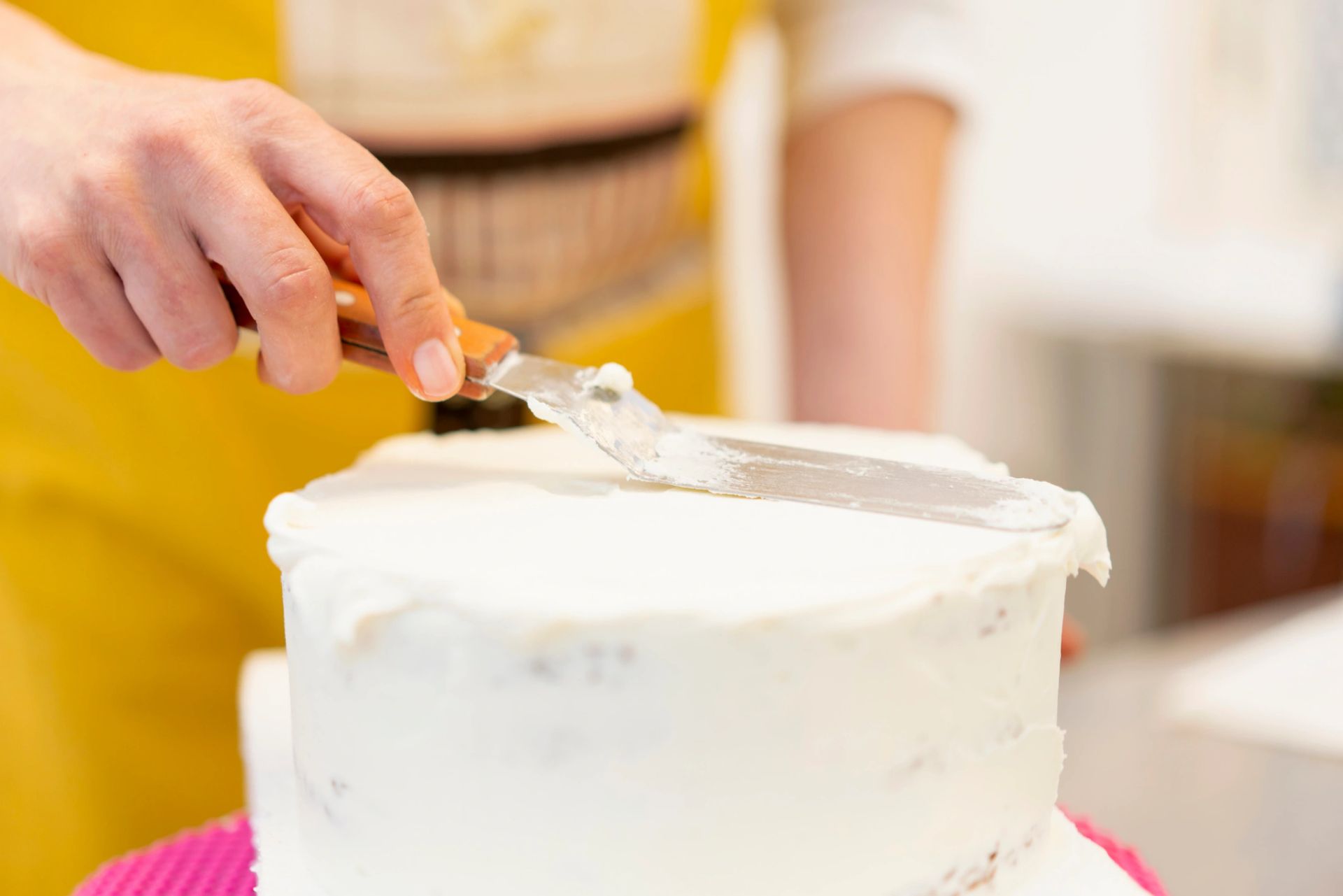 A cake being smoothly iced by hand
